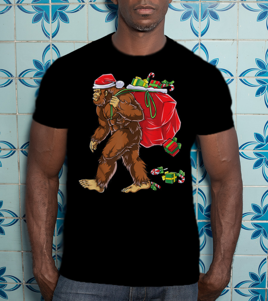 Bigfoot Santa With Giant Red Christmas Bag And Green Gifts Wearing Xmas Hat T-Shirt