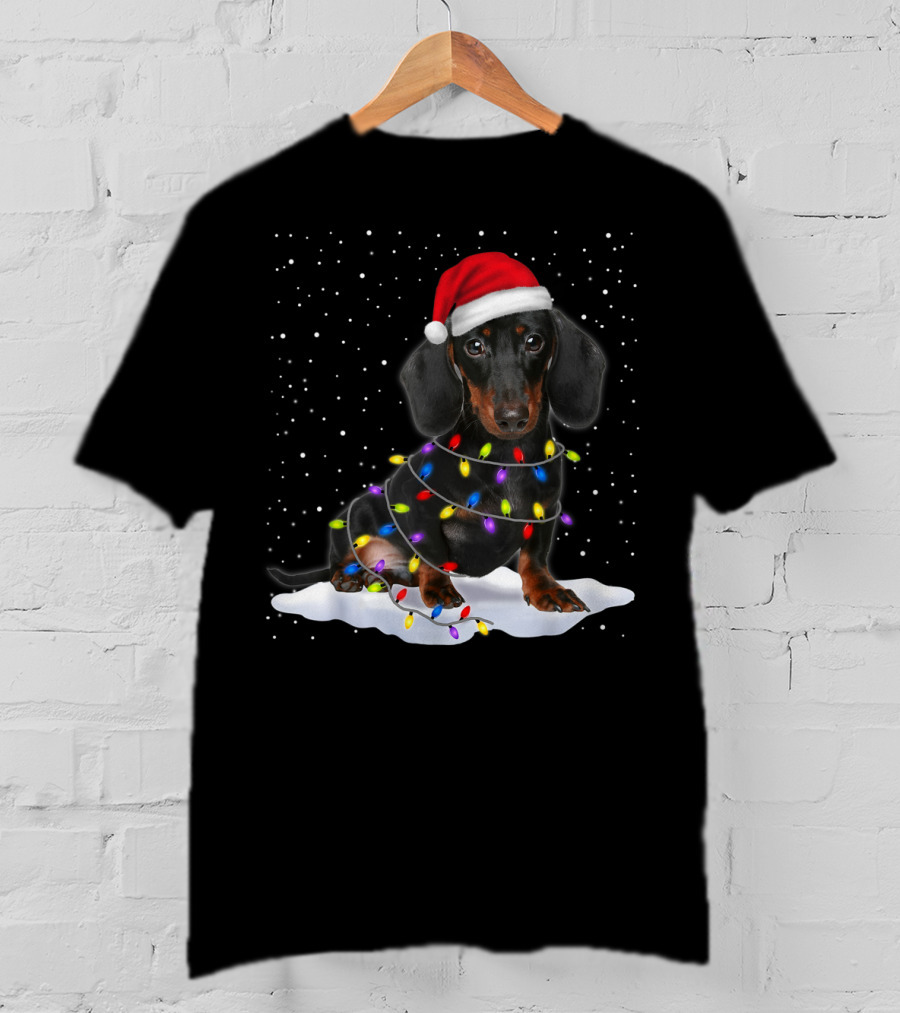 Dachshund Santa Hat Wrapped In Christmas Tree Lights In Snow With Falling Snowflakes T-Shirt