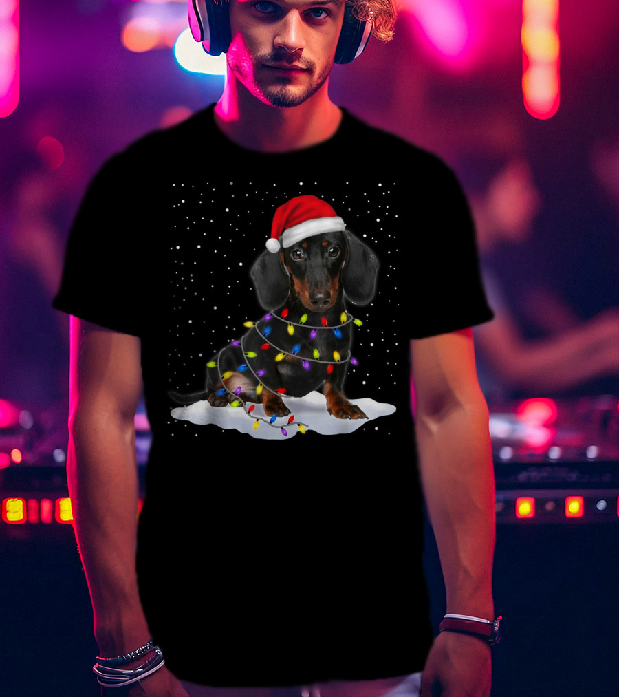 Dachshund Santa Hat Wrapped In Christmas Tree Lights In Snow With Falling Snowflakes T-Shirt