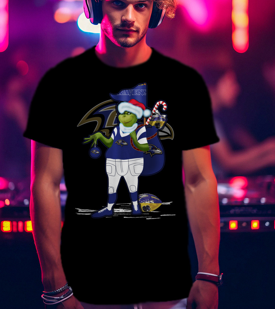 Grinch Santa Holding Candy Cane Bag And Baltimore Ravens Football In Ravens T-Shirt