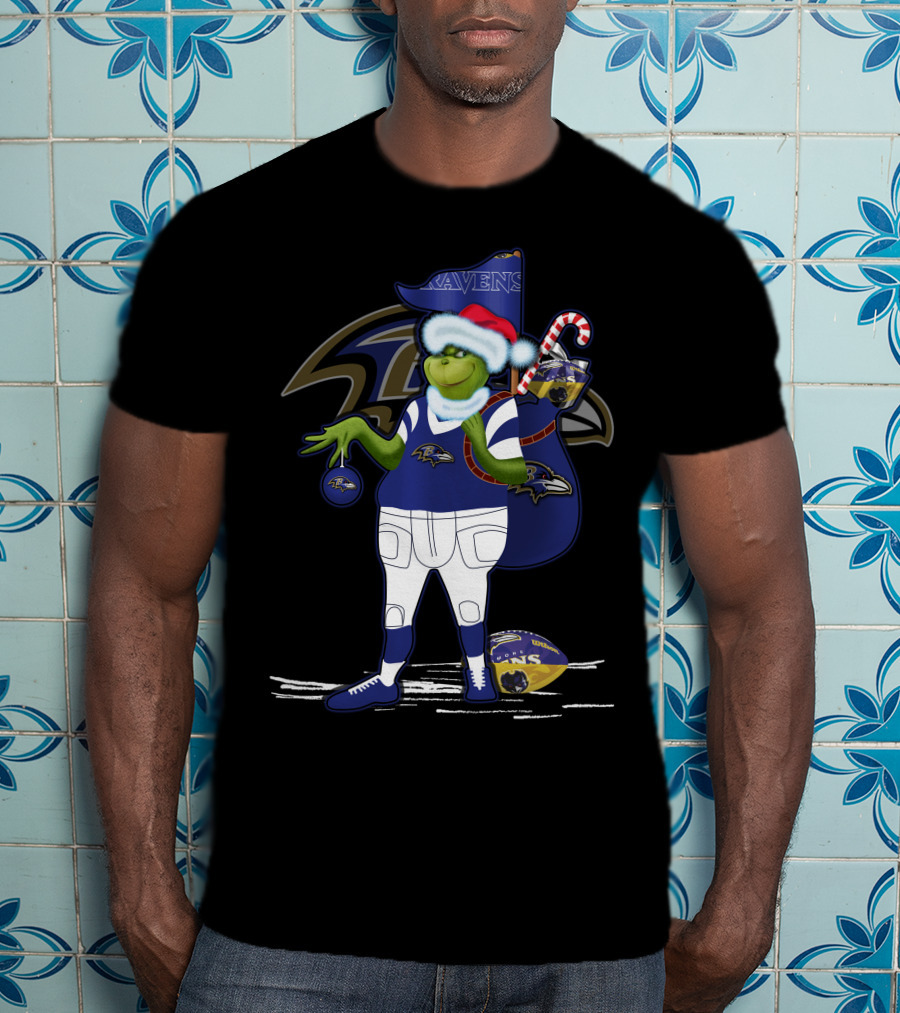 Grinch Santa Holding Candy Cane Bag And Baltimore Ravens Football In Ravens T-Shirt