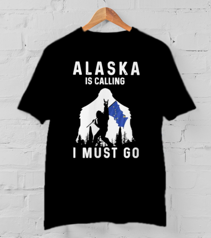 Alaska Is Calling I Must Go Bigfoot Holding Alaska Flag T-Shirt