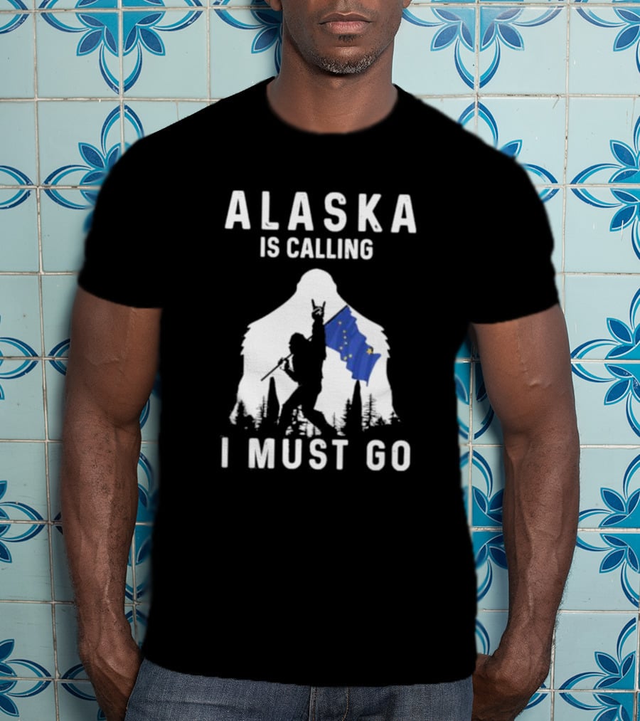 Alaska Is Calling I Must Go Bigfoot Holding Alaska Flag T-Shirt