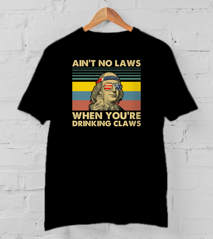 Ain't No Laws When You're Drinking Claws Vintage Benjamin Franklin With American Flag Glasses And Headband Can Of Clarified Beverage Stripes Background T-Shirt
