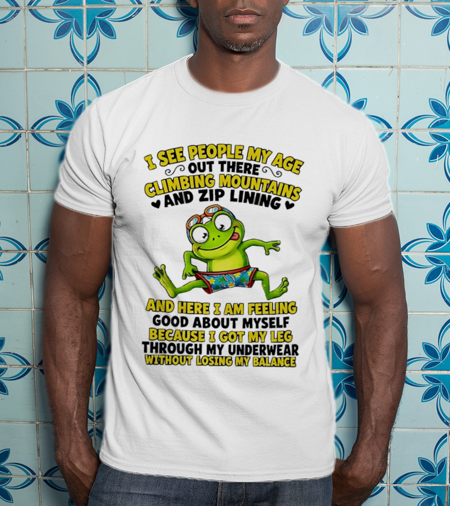 I See People My Age Climbing Mountains And Zip Lining Cartoon Frog Feeling Good Without Losing Balance T-Shirt